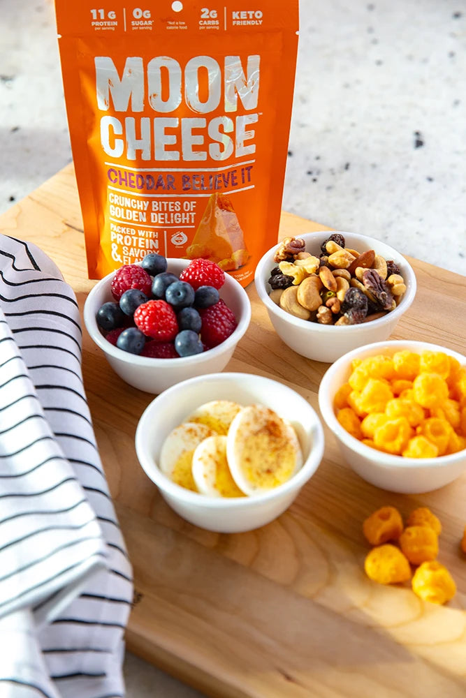 gluten free sugar free keto friendly high protein cheddar believe it moon cheese with nuts meats and fruit on a grazing board