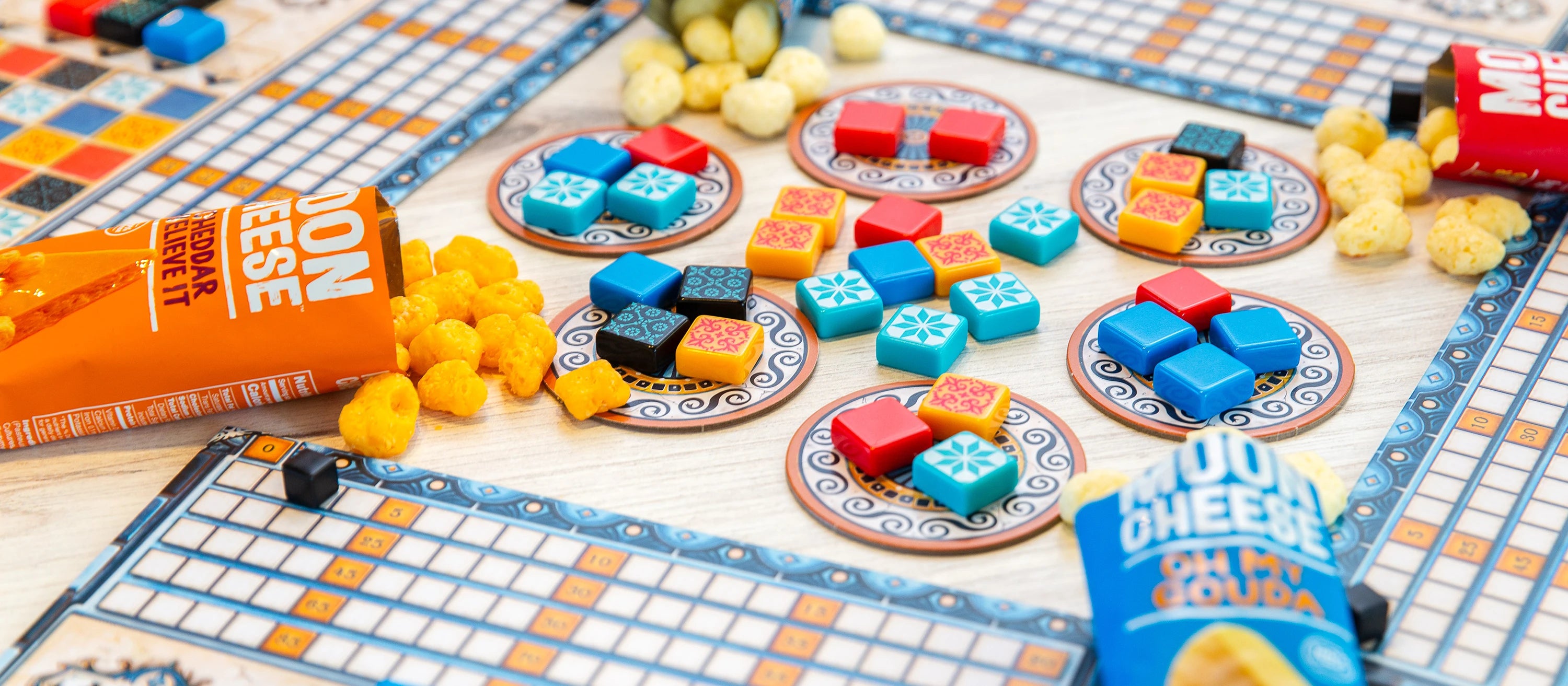 snack packages of gluten free sugar free keto friendly high protein oh my gouda and cheddar believe it moon cheese on an Azul game board