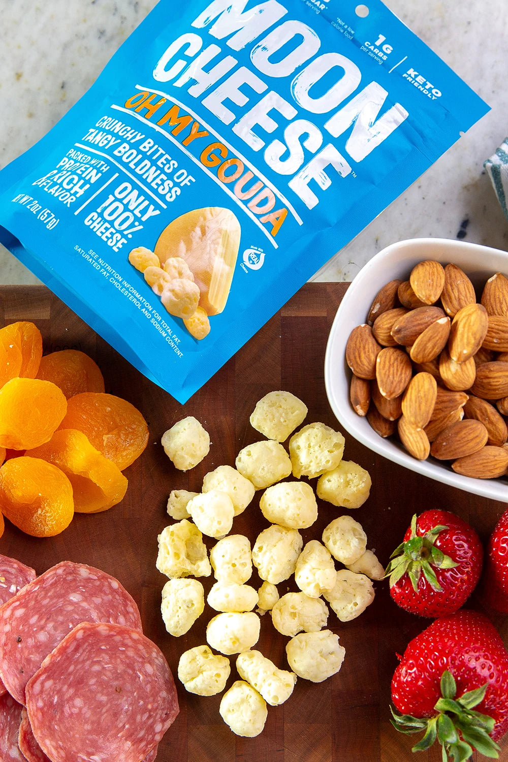 gluten free sugar free keto friendly high protein oh my gouda moon cheese with nuts meats and fruit on a grazing board