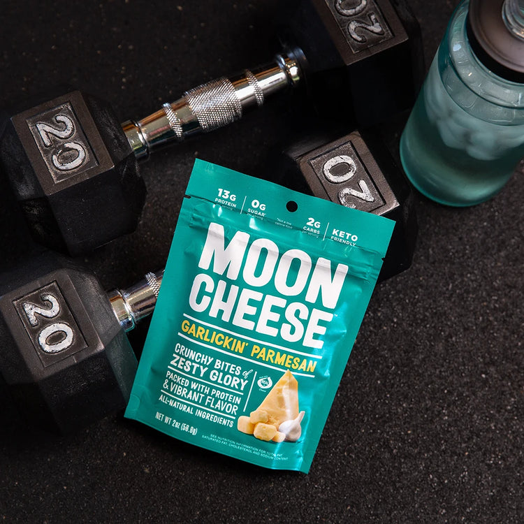 gluten free sugar free keto friendly high protein garlickin parmesan moon cheese with a water bottle and dumb bells at the gym
