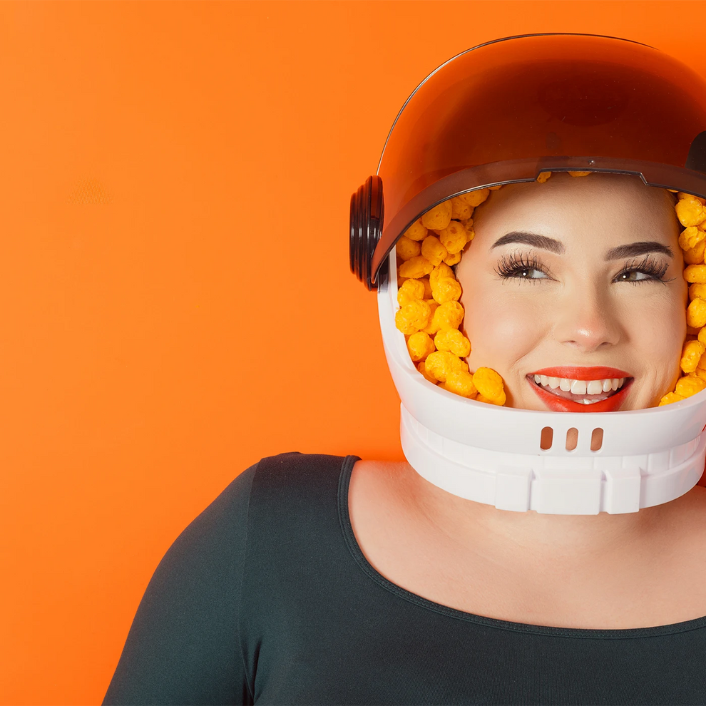 Smiling young woman with a space helmet filled with high protein gluten free sugar free moon cheese