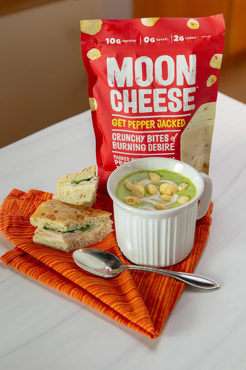 gluten free sugar free keto friendly high protein get pepper jacked moon cheese sprinkled on soup in a mug with a sandwich and package