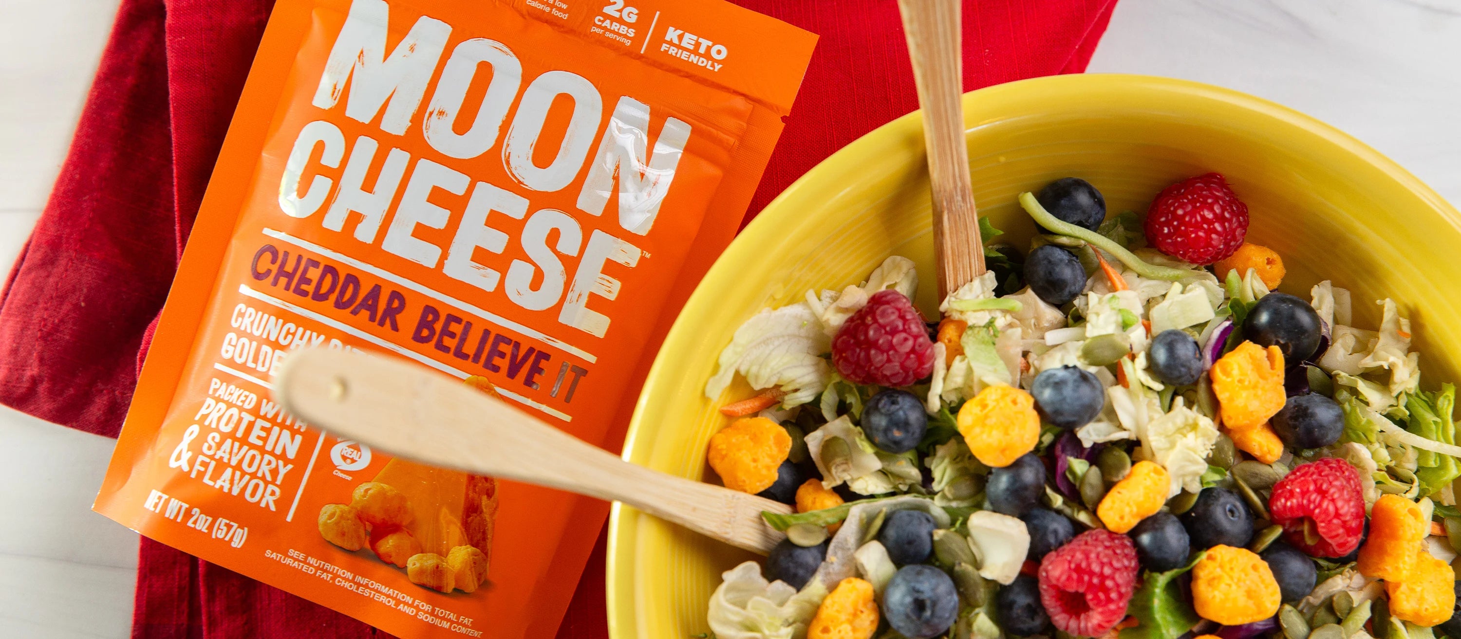 gluten free sugar free keto friendly high protein cheddar believe it moon cheese sprinkled like croutons on a salad next to the package