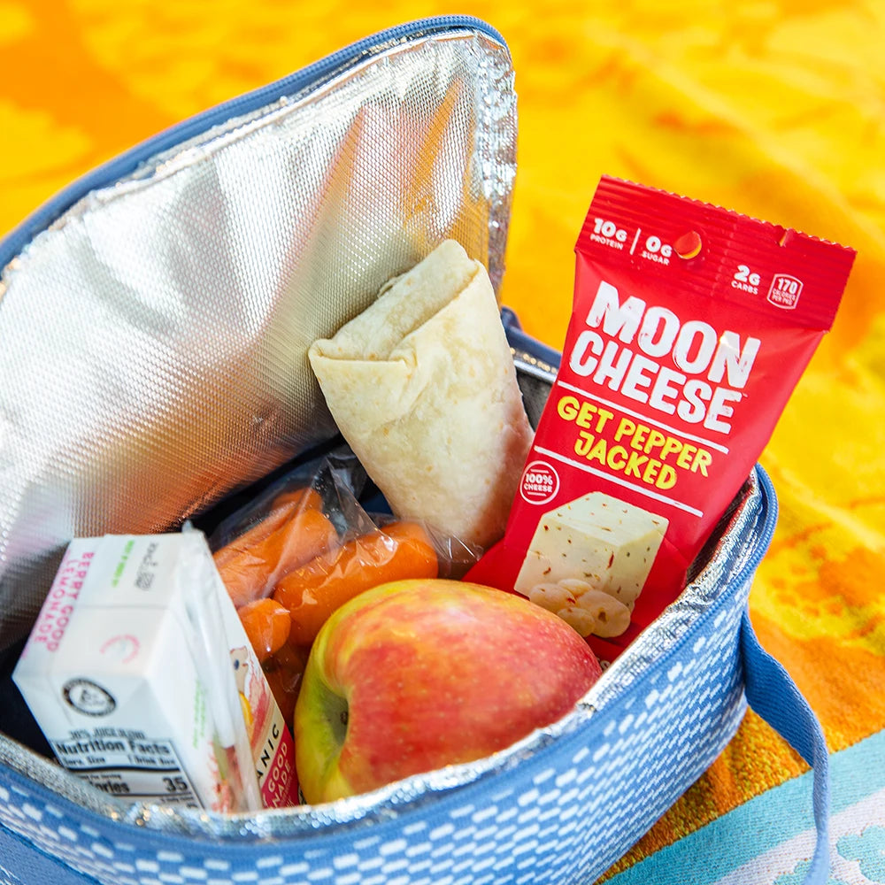 gluten free sugar free keto friendly high protein get pepper jacked moon cheese in a lunch bag with an apple, carrots, juice box and a wrap